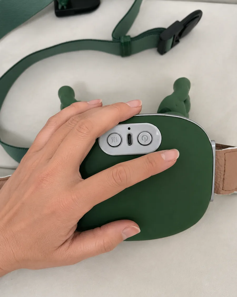 Une main posée a plat sur la coque du châle de massage éteint, cadrage serré